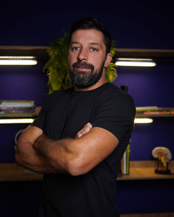 Fabio Alves de Araújo de braços cruzados em seu escritório